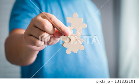 Child assembles puzzle pieces home setting indoor activity creative play focused exploration 131832101