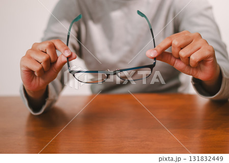 Person adjusting glasses at home focused moment lifestyle cozy environment close-up view eye care concept 131832449
