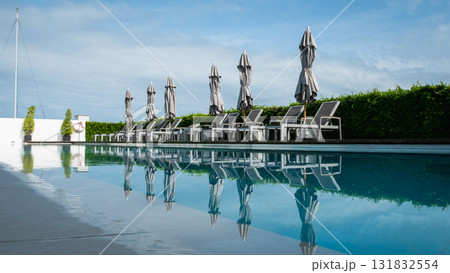 Relaxing poolside lounge experience luxury hotel sunny day low angle tranquility and comfort Relaxing poolside lounge experience luxury hotel sunny day low angle tranquility and comfort 131832554