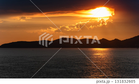 Dramatic sunset over mountainous coastline serene ocean landscape evening glow Dramatic sunset over mountainous coastline serene ocean landscape evening glow 131832605