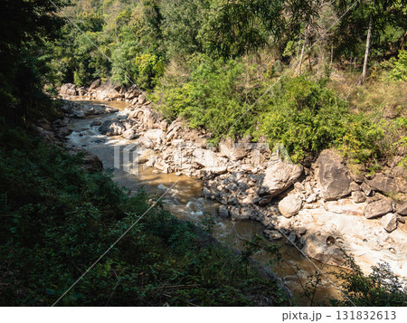 Scenic river flowing through lush forest nature serene environment daylight viewpoint 131832613