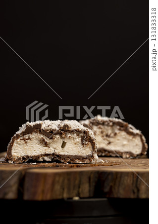 cut marshmallows in chocolate sprinkled with coconut chips, sweet dessert marshmallows in milk chocolate with coconut cut in half 131833318