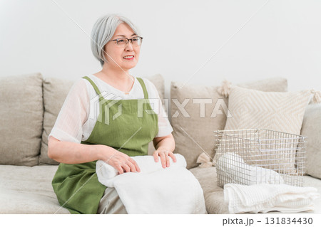 自宅のリビングで洗濯物を畳むシニアのアジア人女性(家事,主婦,専業主婦) 自宅のリビングで洗濯物を畳むシニアのアジア人女性(家事,主婦,専業主婦) 131834430