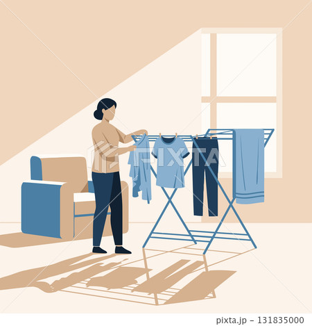 Young woman hanging laundry on drying rack 131835000