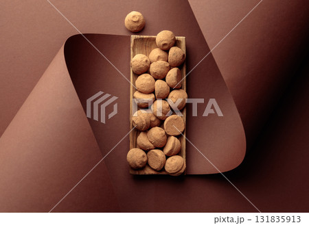 Chocolate truffles on a brown background. 131835913