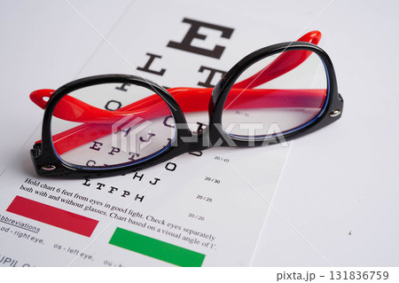 Glasses on eye exam chart to test eyesight accuracy of reading. Glasses on eye exam chart to test eyesight accuracy of reading. 131836759