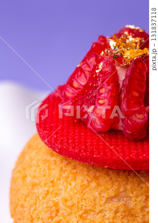 Macro of dessert with raspberry and gold - luxury, texture and bold colors on purple Macro of dessert with raspberry and gold - luxury, texture and bold colors on purple 131837118