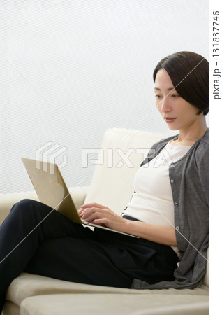ソファに座ってパソコンで仕事をする女性 131837746