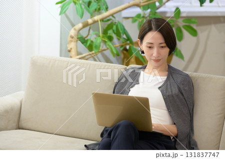 ソファに座ってパソコンで仕事をする女性 131837747