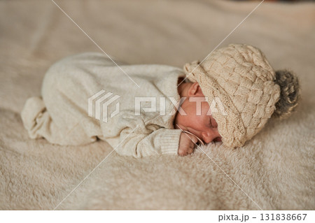 Full body top-down view of a newborn baby peacefully sleeping with a pacifier in a neutral cable 131838667