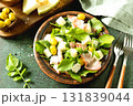 Fresh arugula salad with prosciutto, melon, and olives for a delicious summer meal. 131839044