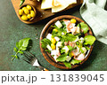Fresh arugula salad with prosciutto, melon, and olives for a delicious summer meal. Top view flat lay. 131839045