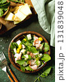 Fresh arugula salad with prosciutto, melon, and olives for a delicious summer meal. Top view flat lay 131839048