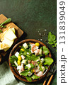 Fresh arugula salad with prosciutto, melon, and olives for a delicious summer meal. Top view flat lay background. 131839049