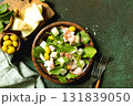 Fresh arugula salad with prosciutto, melon, and olives for a delicious summer meal. Top view flat lay. 131839050
