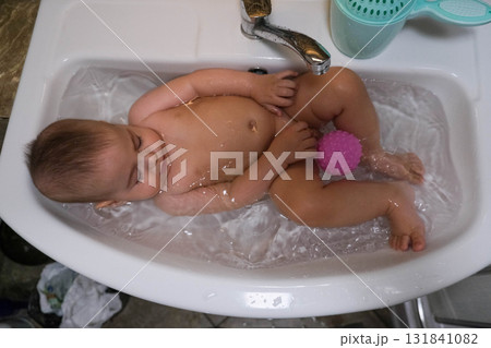 Baby enjoying bath time in a small tub Baby enjoying bath time in a small tub 131841082