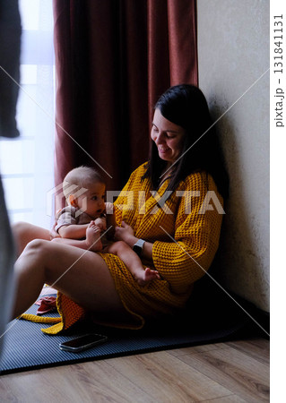 Mother and baby enjoying a cozy moment indoors Mother and baby enjoying a cozy moment indoors 131841131