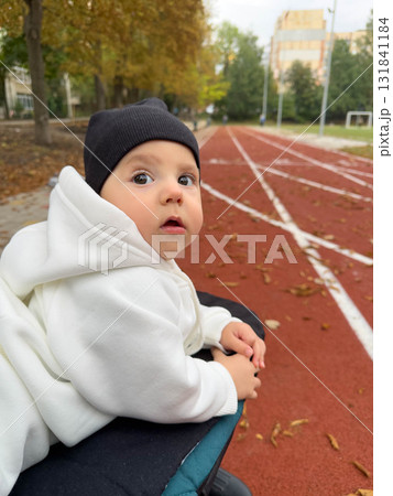 Baby in Hoodie on Track Field in Autumn Baby in Hoodie on Track Field in Autumn 131841184