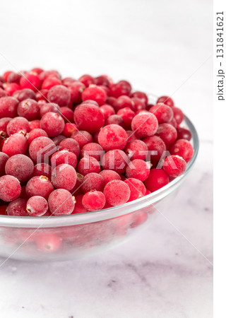 bowl of frozen cranberries on light background. Preservation of vegetables and fruits. Natural products bowl of frozen cranberries on light background. Preservation of vegetables and fruits. Natural products 131841621