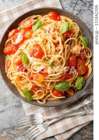 Margherita Spaghetti made with tomatoes, basil, and mozzarella closeup on the plate. Vertical top view 131842306