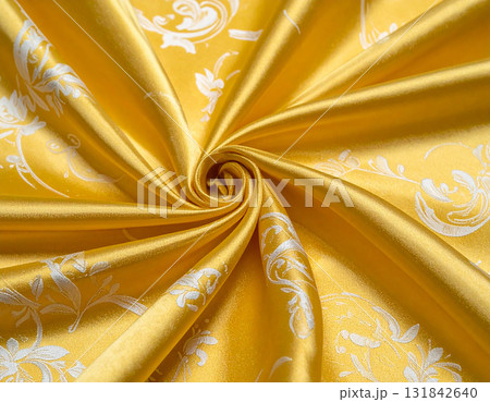 輝く黄金のドレープに白い刺繍が際立つ豪華なシルク生地 輝く黄金のドレープに白い刺繍が際立つ豪華なシルク生地 131842640