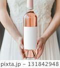 Rose wine bottle mockup held by bride with blank label for wedding or bridesmaid announcement. 131842948