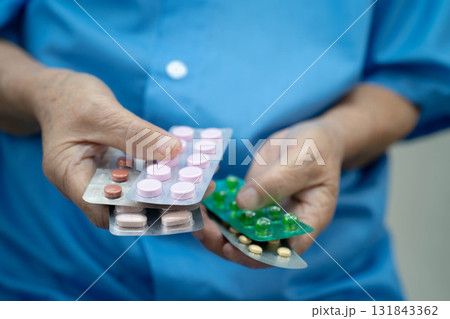 Asian elderly woman holding pill drug in hand, strong healthy medical concept. 131843362