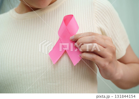 Asian woman with pink ribbon for October world breast cancer day. Asian woman with pink ribbon for October world breast cancer day. 131844154