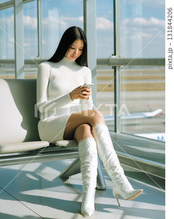 空港ラウンジでスマートフォンを使うエレガントな女性 空港ラウンジでスマートフォンを使うエレガントな女性 131844206