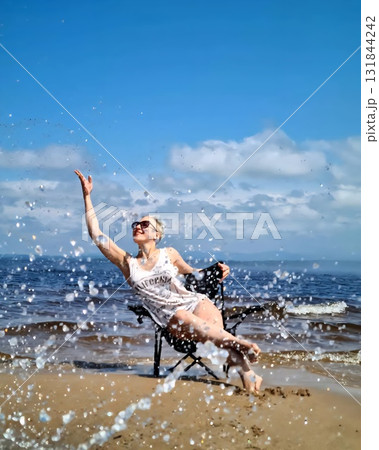Splashing Water Around Woman Sitting On Baikal Shore Splashing Water Around Woman Sitting On Baikal Shore 131844242