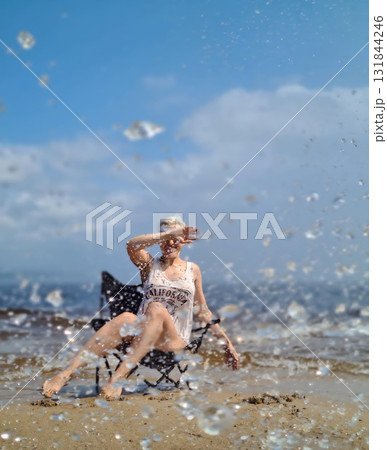 Woman enjoying refreshing summer splashes on sandy Baikal shore Woman enjoying refreshing summer splashes on sandy Baikal shore 131844246