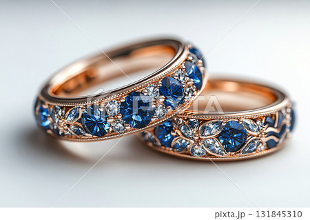 Luxurious pair of wedding rings with blue stones on a white background. Rococo-Renaissance style. 131845310