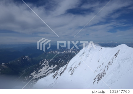 Tranquil Lake With Lush Green Forest, Snow-Capped Mountain, Blue Sky And White Clouds 131847760