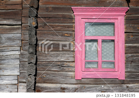 A vintage wooden window frame in an old log wall. 131848195