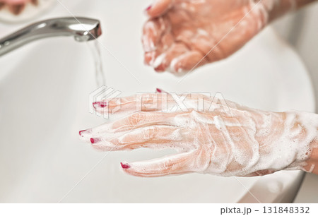Young woman washing her hands under water tap faucet with soap. Detail on suds covered skin. Personal hygiene concept 131848332