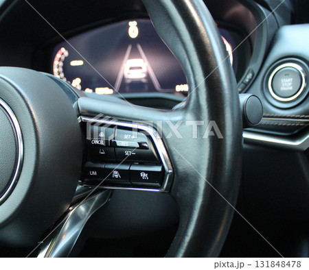 System Buttons on a Multifunctional Steering Wheel of Modern Car. Defocused Dashboard Behind Steering Wheel System Buttons on a Multifunctional Steering Wheel of Modern Car. Defocused Dashboard Behind Steering Wheel 131848478