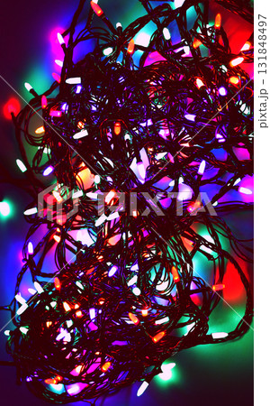 Shining Electric Garland with Intertwined Wires in Darkness. Glowing Garland Vertical Background 131848497