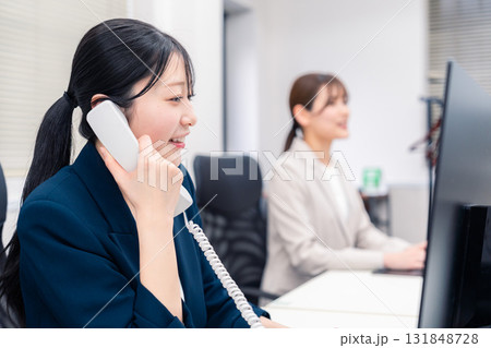 オフィスでにこやかに電話対応をするビジネスウーマン オフィスでにこやかに電話対応をするビジネスウーマン 131848728