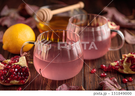 Autumn Beverage: two Cups ofPomegranate Tea with Lemon and Ginger on Rustic Table Autumn Beverage: two Cups ofPomegranate Tea with Lemon and Ginger on Rustic Table 131849000
