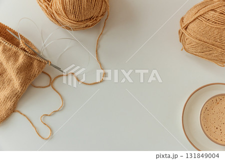 Knitting Project with Cup of Cappuccino on White Table in Cozy Setting 131849004