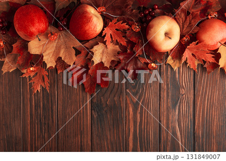 Autumn Arrangement with Apples, Leaves, Berries, and Decorative Pumpkin Lights on Wooden Surface 131849007