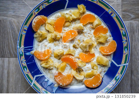 Oatmeal breakfast with banana and mandarin on blue plate Oatmeal breakfast with banana and mandarin on blue plate 131850239