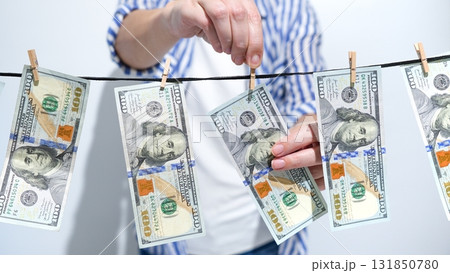 Money Laundering Concept Person Hanging Hundred Dollar Bills on Clothesline to Dry. Finance Theme Money Laundering Concept Person Hanging Hundred Dollar Bills on Clothesline to Dry. Finance Theme 131850780