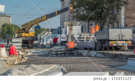 Loader crane for loading and unloading sleepers from truck which stands on a road construction site aerial timelapse 131851125
