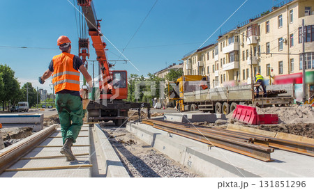 Orange construction telescopic mobile crane unloading tram rails from truck timelapse. Orange construction telescopic mobile crane unloading tram rails from truck timelapse. 131851296