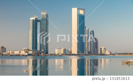 Abu Dhabi city skyline with skyscrapers after sunrise with water reflection timelapse 131851613
