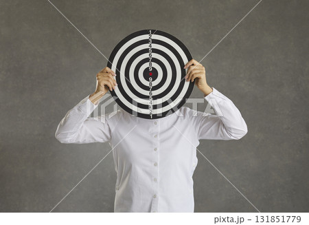 Woman hiding her face behind a shooting target as a concept of setting a business goal 131851779