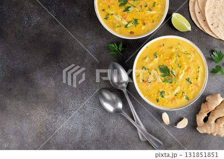 Traditional Indian Mulligatawny soup with lentils and chicken on a dark background. Top view. Copy space Traditional Indian Mulligatawny soup with lentils and chicken on a dark background. Top view. Copy space 131851851