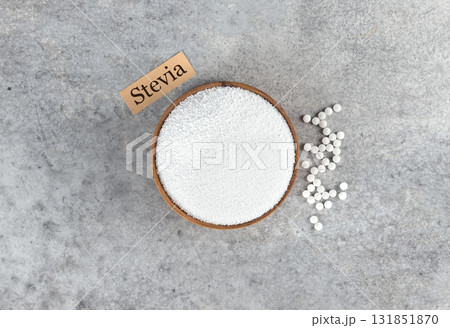 Stevia, a natural sugar substitute, on a gray background. Concept for weight loss. Top view. Stevia, a natural sugar substitute, on a gray background. Concept for weight loss. Top view. 131851870