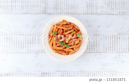 Italian pasta arrabbiata with tomato sauce, chili pepper, parmesan on wooden background. Top view Italian pasta arrabbiata with tomato sauce, chili pepper, parmesan on wooden background. Top view 131851871